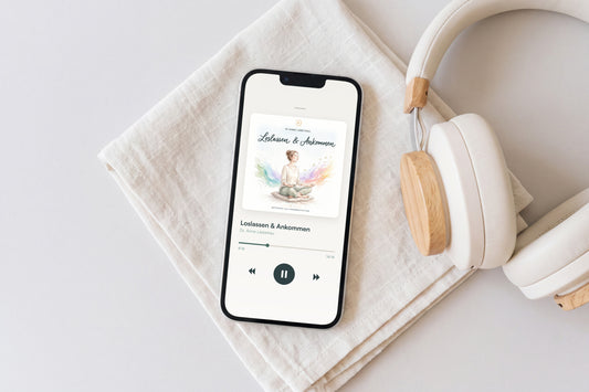 Smartphone mit dem Cover der Meditation „Loslassen & Ankommen“ auf Leinen, daneben Kopfhörer