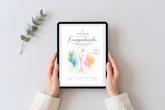 Hände halten ein Tablet mit dem Cover des Workbooks Energiedusche von Dr. Anne Liebetrau, daneben ein Eukalyptuszweig auf hellem Grund